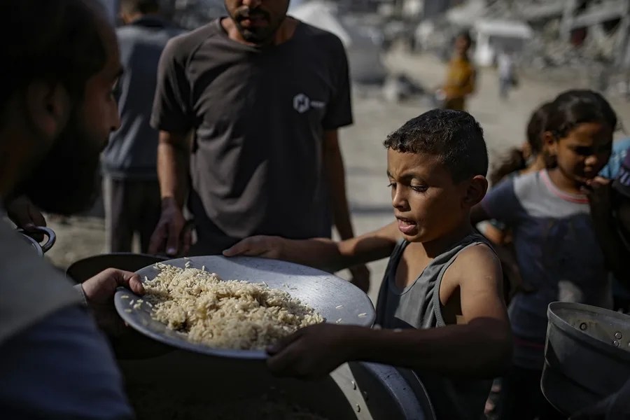 Niños palestinos reciben alimentos de un comedor social en la ciudad de Gaza