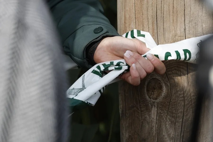 Una agente de la Guardia Civil coloca una cinta.