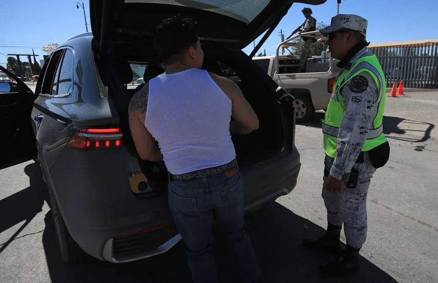 Fotografía del 19 de octubre de 2025 de un integrante de la Guardia Nacional (GN) revisando un vehículo en busca de armas y municiones en Ciudad Juárez (México). EFE/Luis Torres