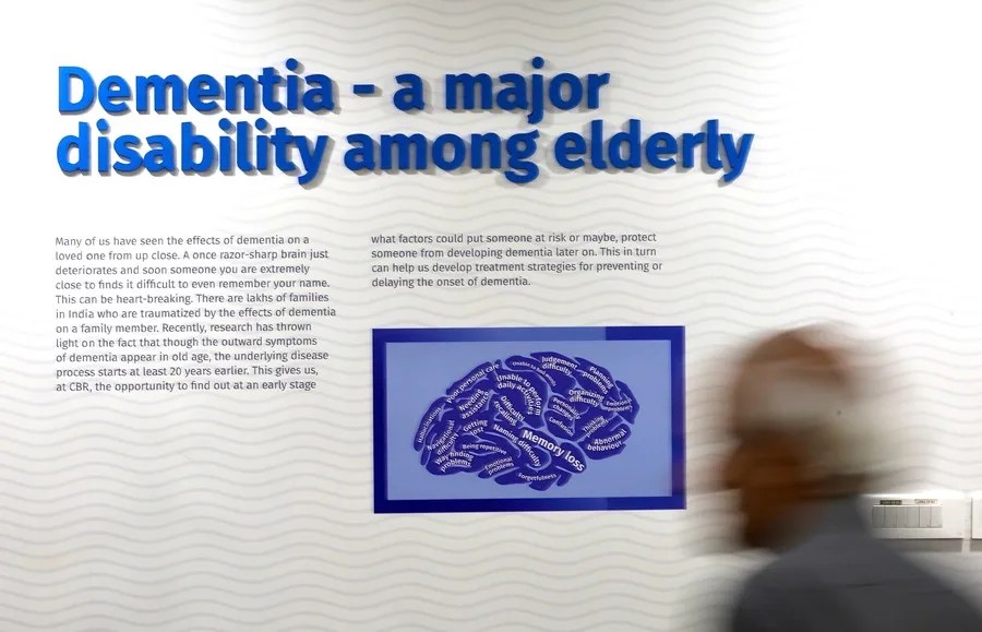 Un asistente camina frente a una valla publicitaria en un seminario de concienciación con motivo del Día Mundial del Alzheimer,