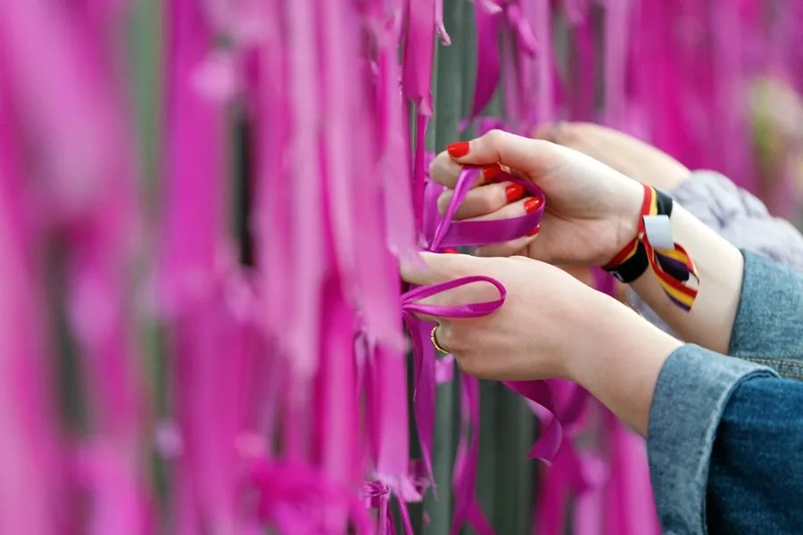 Un grupo de mujeres coloca lazos morados