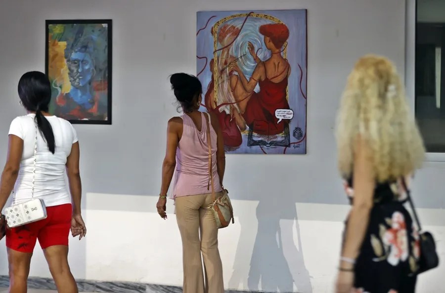 Mujeres observan algunas obras durante una exposición este miércoles, en la Oficina Nacional de Diseño Industrial en La Habana (Cuba). EFE/ Ernesto Mastrascusa