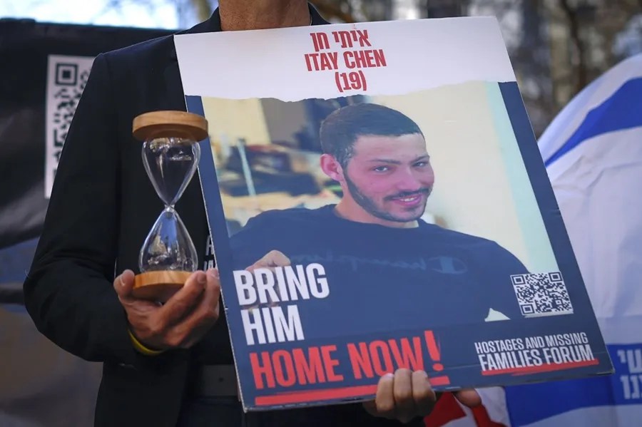 Un familiar de un rehén de Hamás sostiene un reloj de arena y una fotografía de Itay Chen