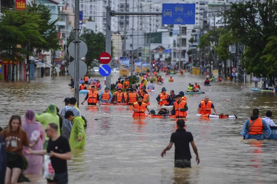 Personas caminan entre las aguas de las inundaciones en Nha Trang, provincia de Khanh Hoa, Vietnam