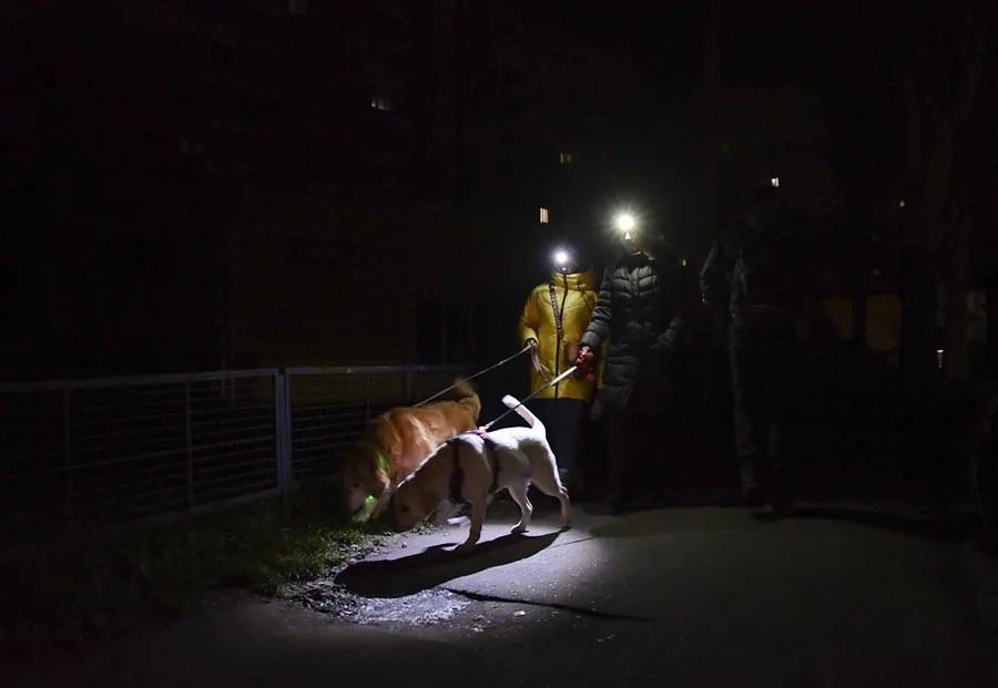 Personas caminan con linternas por una calle oscura durante un apagón en Lviv