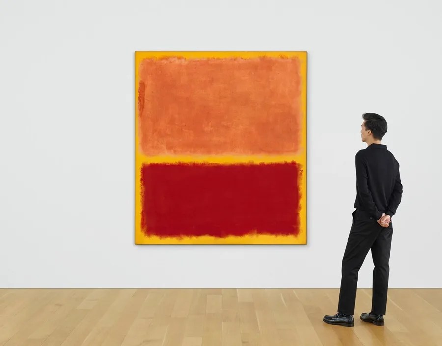 Fotografía cedida por la casa de subastas Christie's de un hombre observando la obra 'No. 31 (Yellow Stripe)' del pintor figurativo estadounidense Mark Rothko