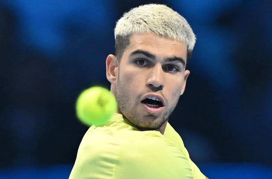 El español Carlos Alcaraz en acción durante el partido de la ronda preliminar individual contra Taylor Fritz