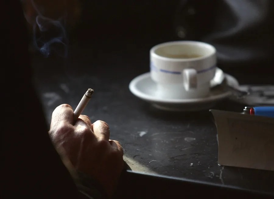 Una persona hombre fuma un cigarro