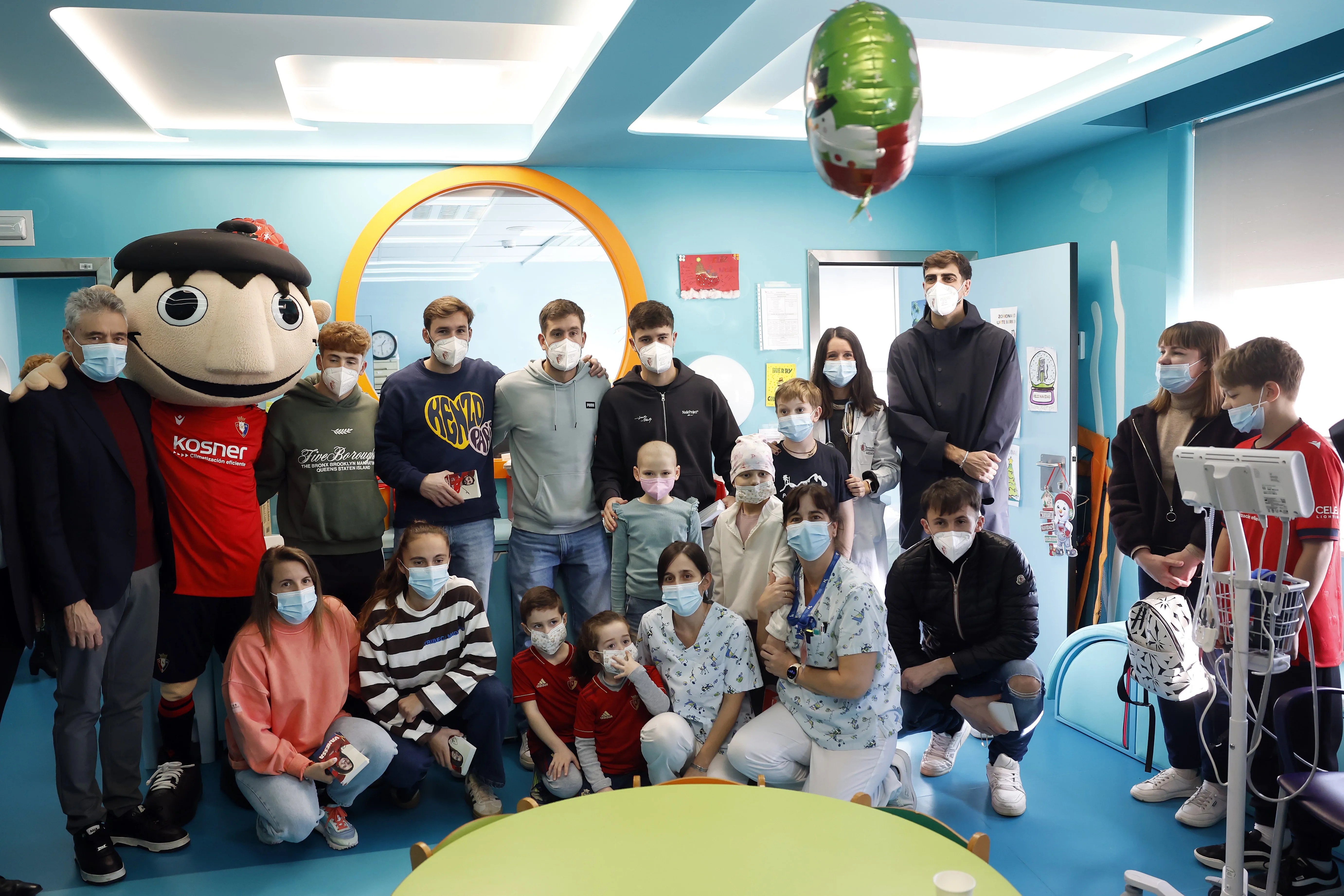 Imagen de la visita de varios jugadores de Osasuna y de la mascota del club, ‘Rojillo’, a los niños ingresados en dos centros hospitalarios de Pamplona