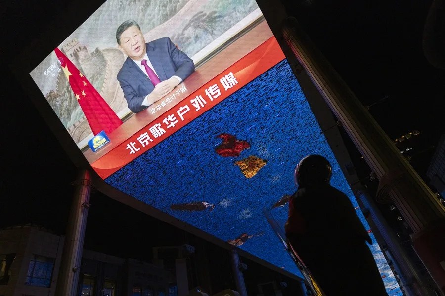 Un guardia de seguridad observa una pantalla que transmite al presidente chino, Xi Jinping, pronunciando su discurso de Año Nuevo