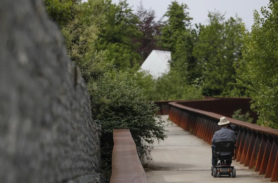 Un hombre pasea con una silla de ruedas
