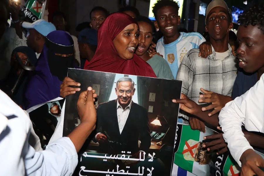 Una mujer sostiene un cartel que representa al primer ministro israelí, Benjamin Netanjahu, mientras los manifestantes se reúnen durante una protesta contra Israel en Mogadiscio, Somalia