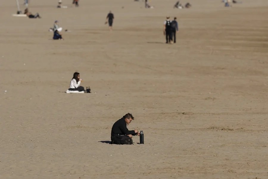 Turistas y valencianos en la playa de la Malvarrosa este lunes.