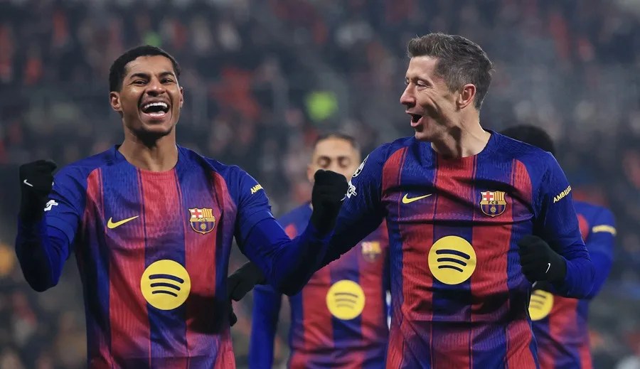 Robert Lewandowski (d) del Barcelona celebra con su compañero Marcus Rashford (i) tras marcar el gol del 2-4