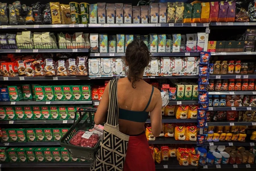 Fotografía de archivo de una mujer comprando café en un supermercado.