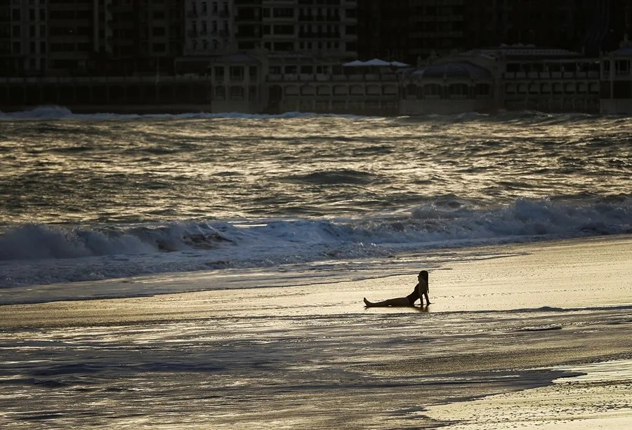 Una joven observa el mar desde la orilla