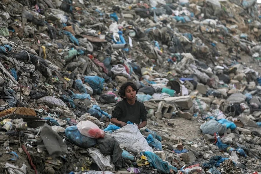 Un niño palestino recoge plástico en un vertedero en el centro de la ciudad de Gaza