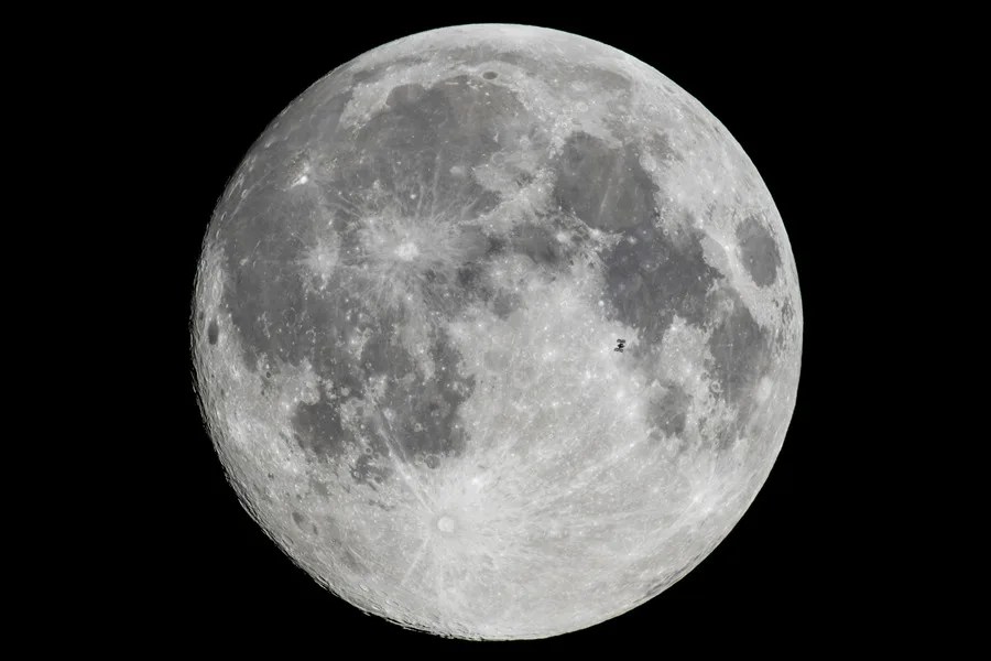 La Estación Espacial Internacional (EEI) orbitando la Tierra, captada en primer plano de la Luna desde Szurdokpuspoki