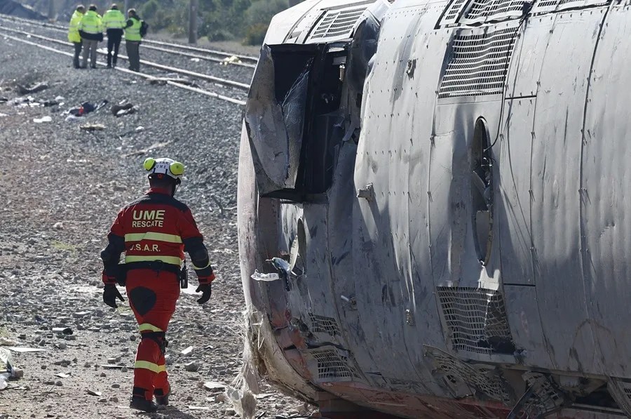 Un miembro de los servicios de emergencia trabaja en uno de los trenes implicados en el accidente