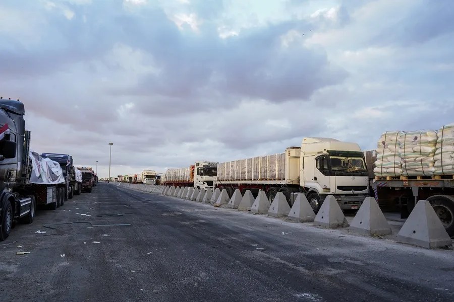 Camiones con ayuda humanitaria se alinean antes de dirigirse al cruce fronterizo de Rafah