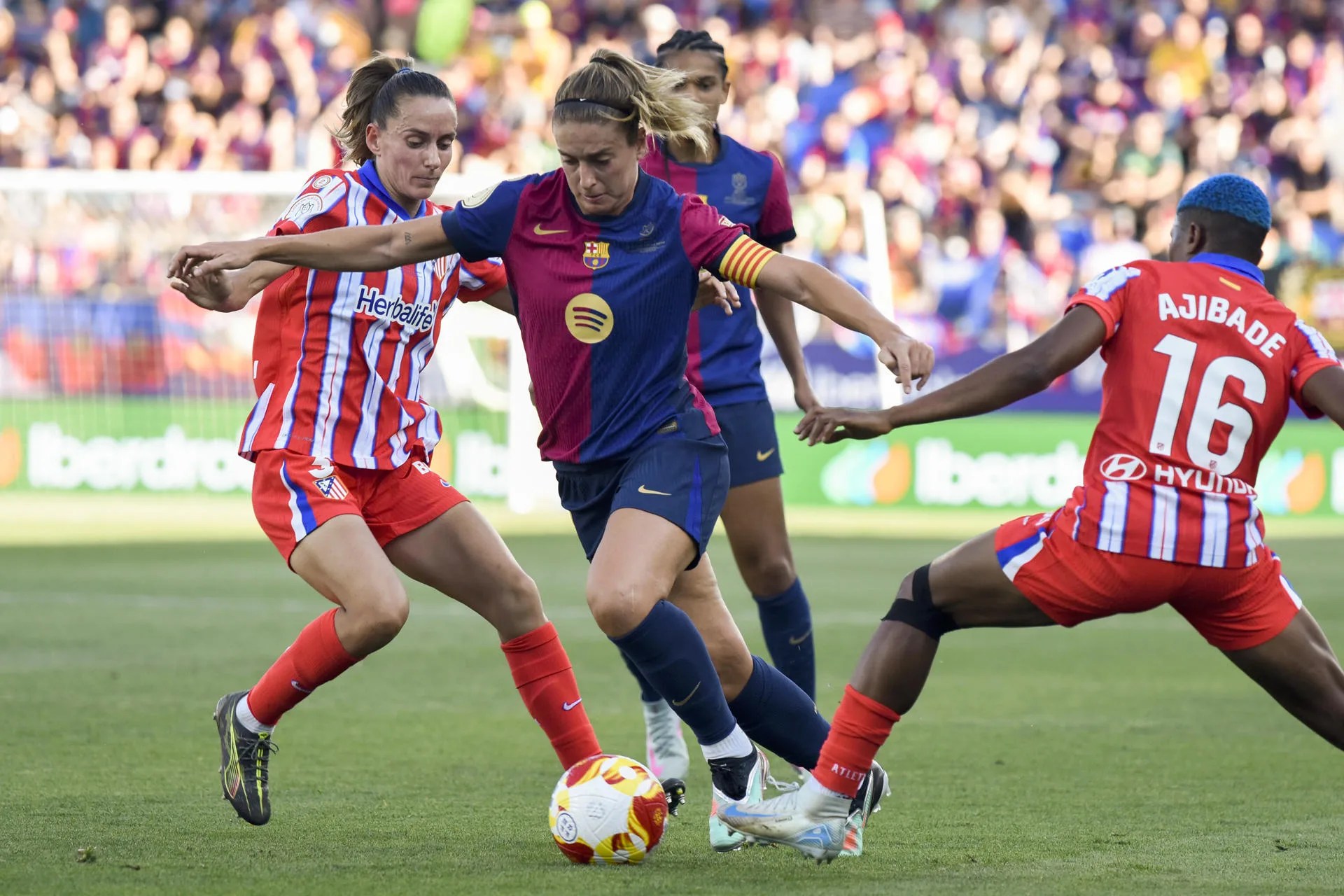 La centrocampista del FC Barcelona Alexia Putellas (c) supera a dos rivales del Atlético de Madrid durante la final de la Copa de la Reina de fútbol de 2025, que se jugó en el estadio de El Alcoraz, en Huesca. EFE/Javier Blasco