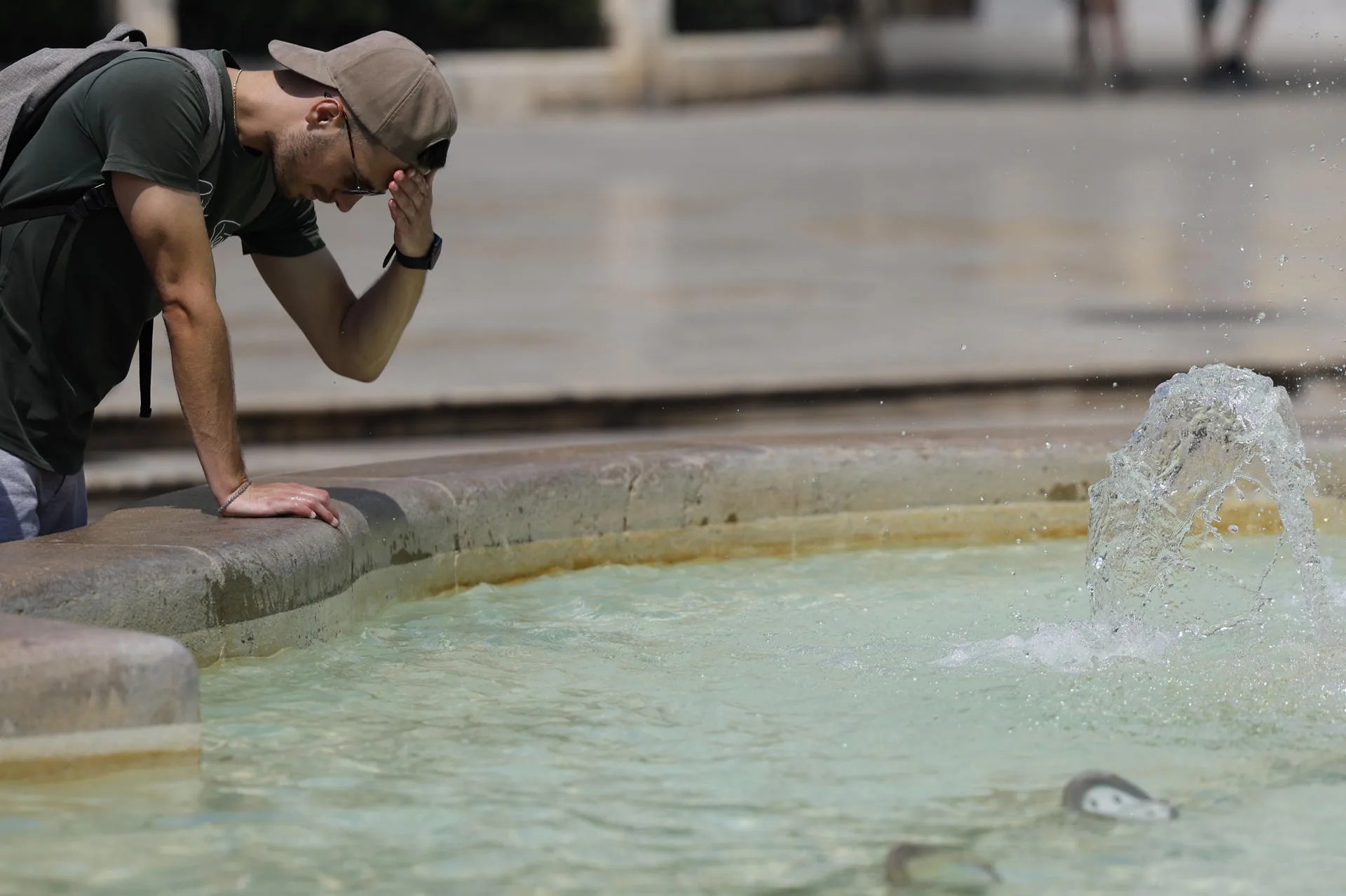 La gente se protege y refresca este martes en el centro de València en un día caluroso. EFE/Ana Escobar

