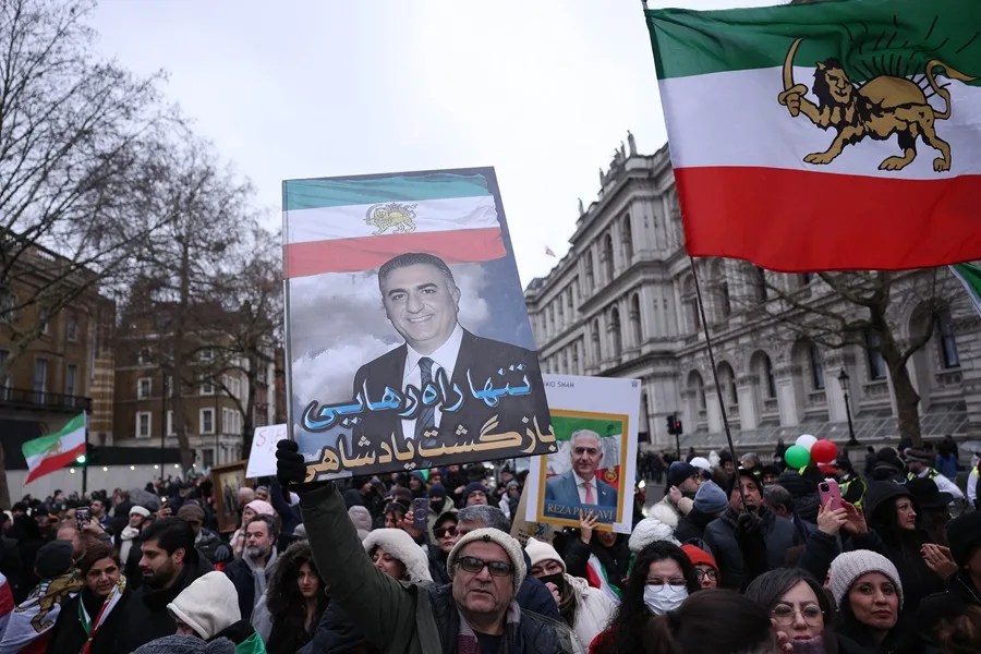 manifestantes ondean banderas iraníes anteriores a la revolución y retratos del príncipe heredero exiliado de Irán, Reza Pahlavi