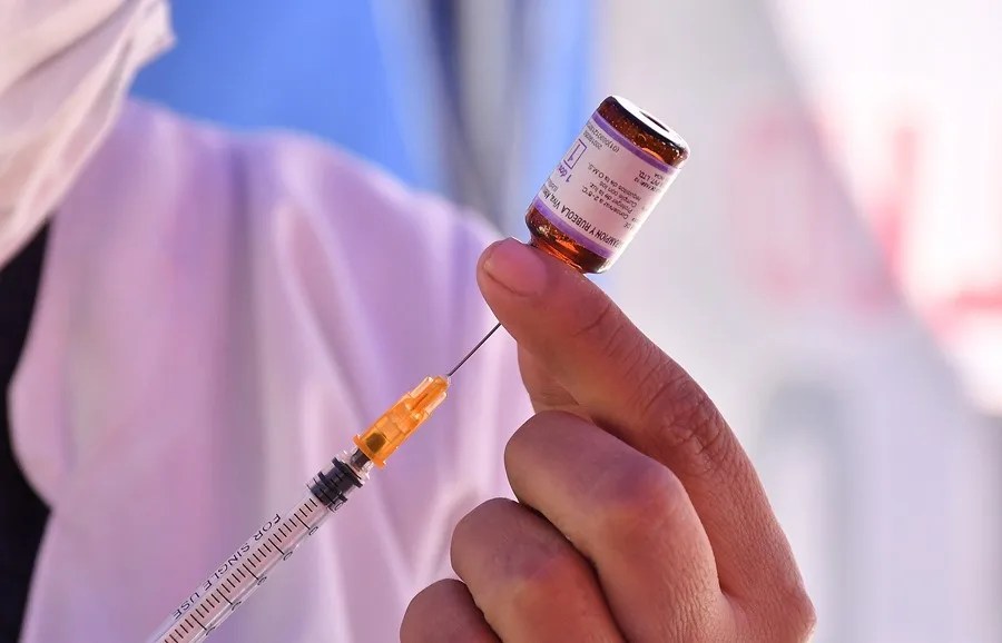 Una persona alista una jeringa con una dosis de vacuna contra el Sarampión