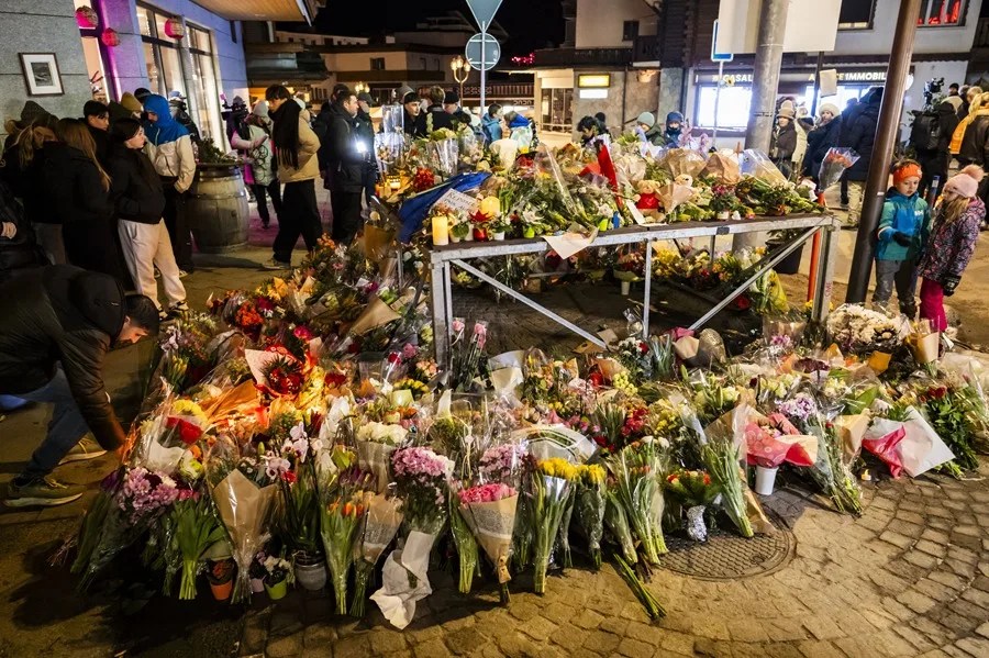 La gente rinde homenaje a las víctimas con flores y velas cerca del área donde se produjo un incendio
