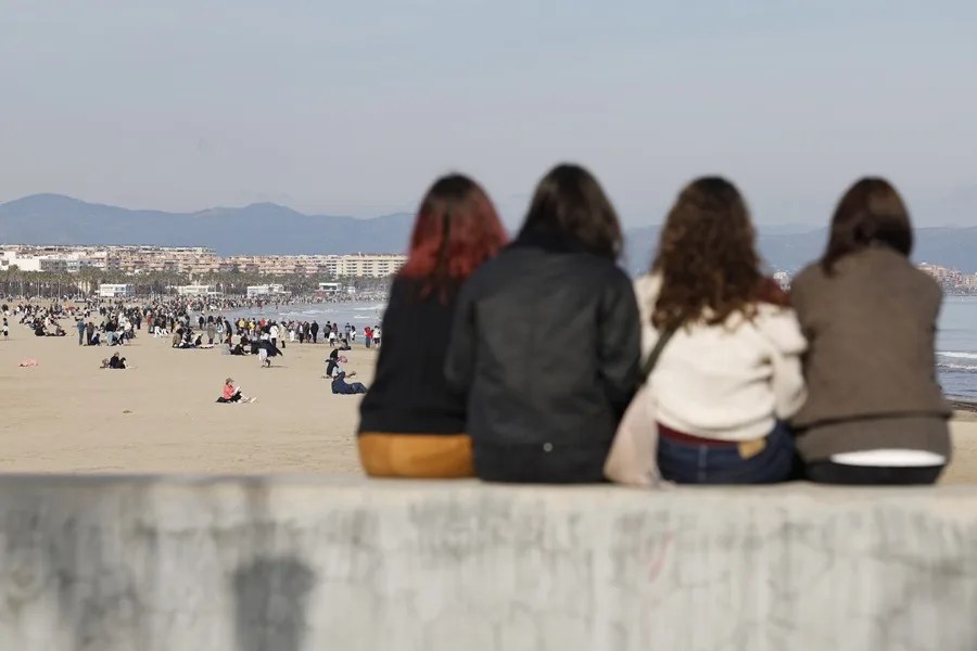 Decenas de personas disfrutan del buen tiempo en la playa de las Arenas en Valencia este jueves