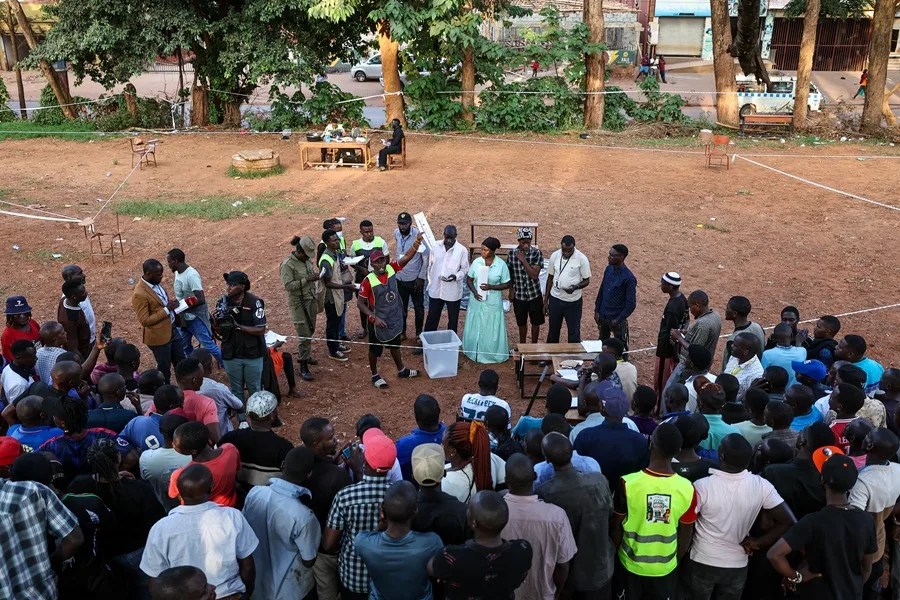 Personas observan la apertura de las urnas durante las elecciones presidenciales en Kampala, Uganda