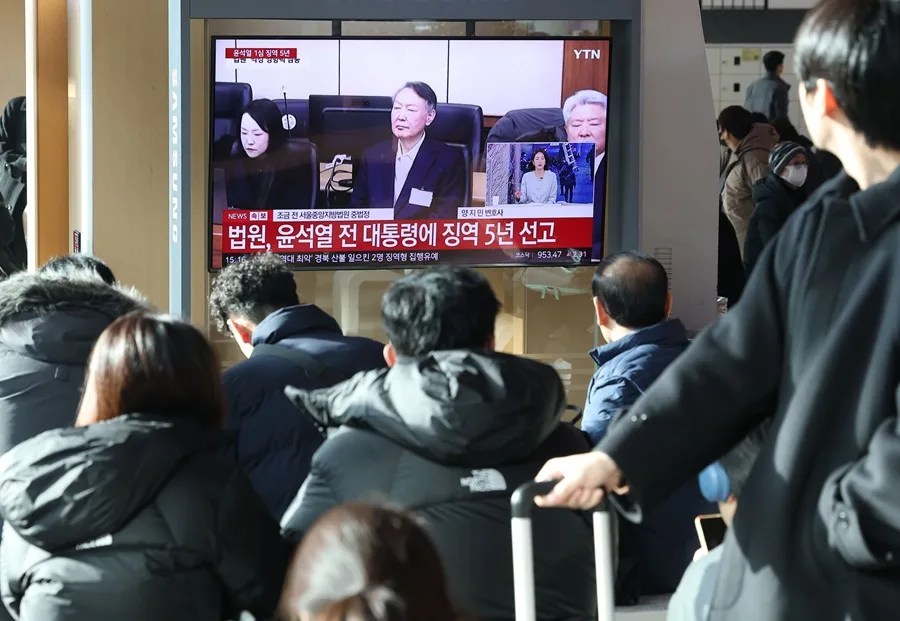 Personas observan una transmisión televisiva en vivo del juicio contra el expresidente surcoreano Yoon Suk Yeol