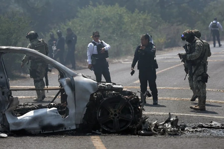Integrantes de la policía de Morelia y del ejército trabajan en la zona donde fue incendiado un vehículo por presuntos integrantes del crimen organizado en Morelia (México). EFE/ Iván Villanueva