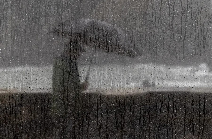 Un hombre camina bajo su paraguas