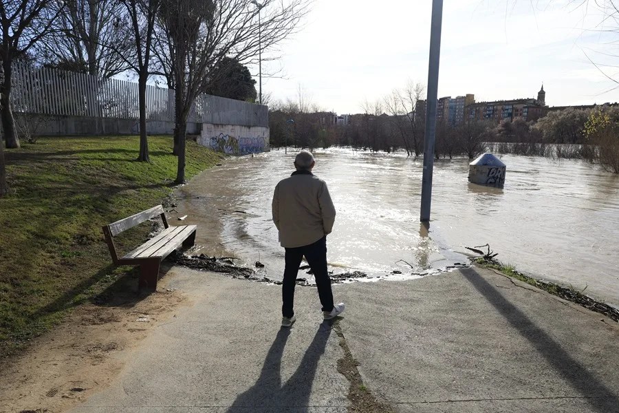Un hombre observa el río Ebro a su paso por Zaragoza.
