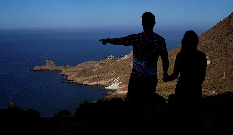 Una pareja de senderistas observa las vistas desde el mirador de la Vela Blanca en el interior del Parque NaturaL Cabo de Gata.