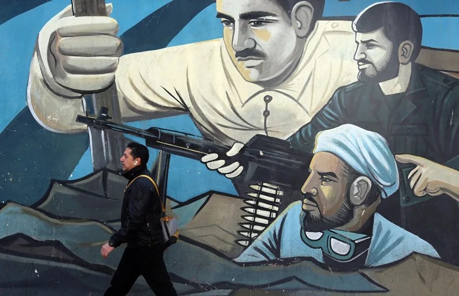 Un hombre iraní pasa junto a un mural de soldados revolucionarios iraníes en Teherán.