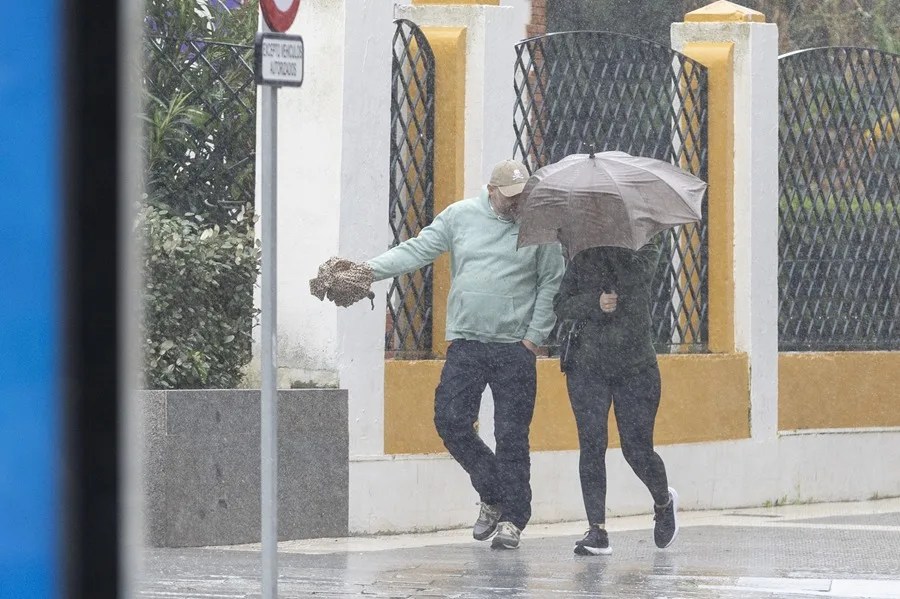 Una mujer se protege del viento y la lluvia
