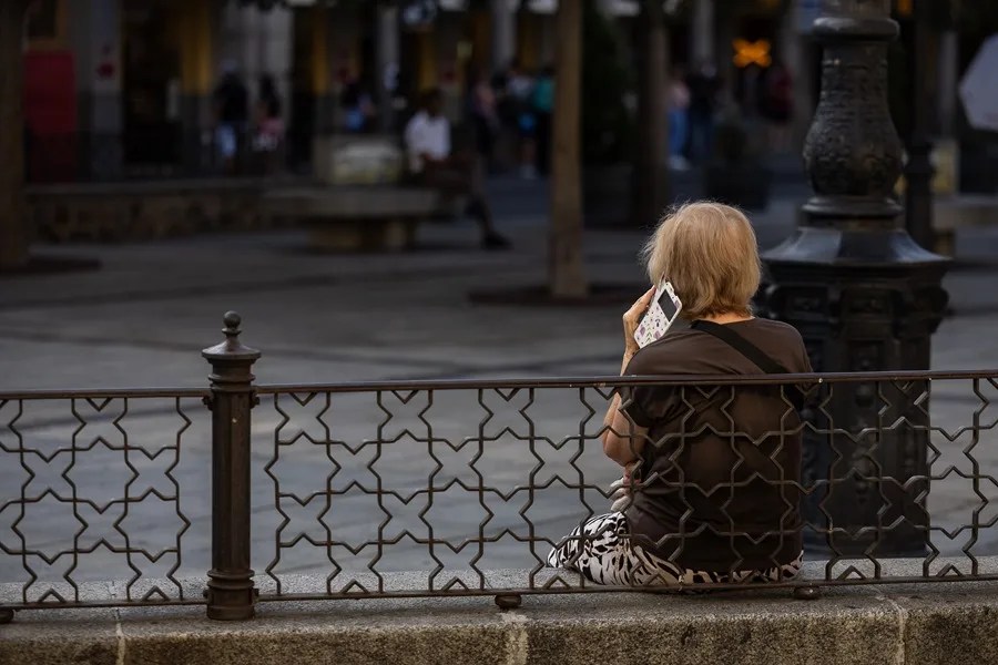 Una mujer habla por teléfono en un parque.