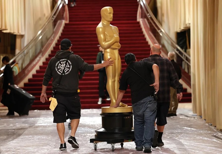 Trabajadores transportan una estatuilla del Oscar por la alfombra roja