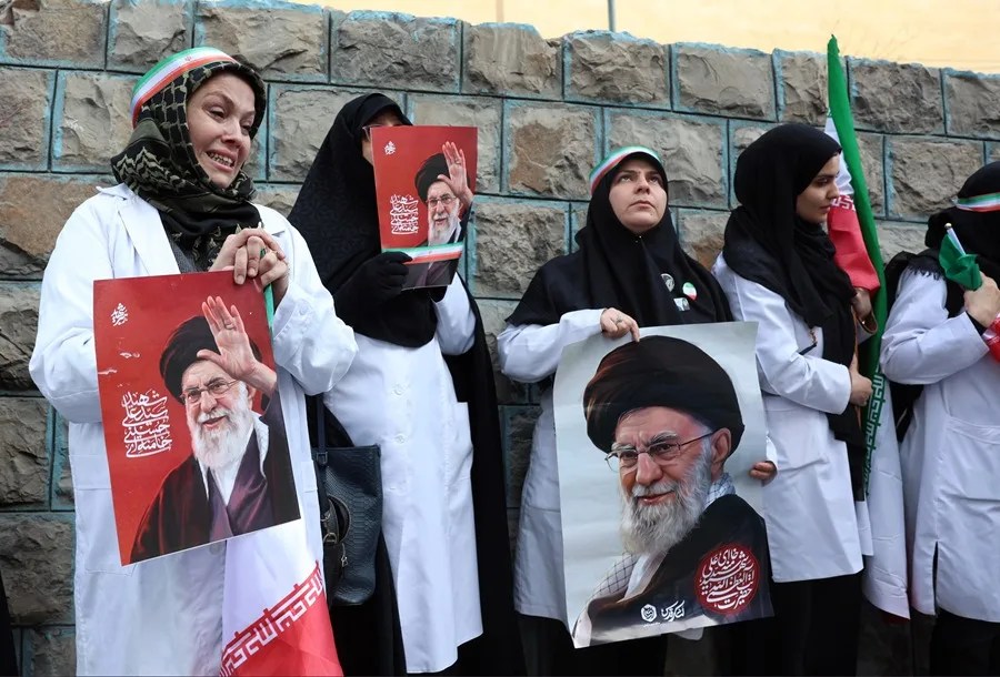 Personal médico iraní sostiene carteles del difunto líder supremo iraní, el ayatolá Alí Jamenei