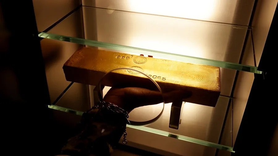 Un empleado del Banco Central recoge un lingote de oro.