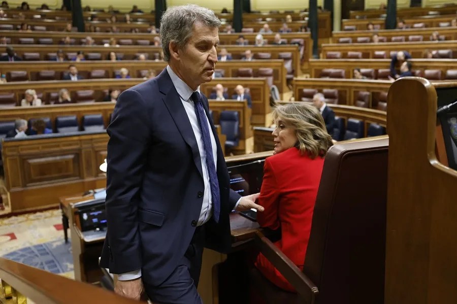 El líder del PP, Alberto Núñez Feijóo, pasa junto a Cuca Gamarra durante la sesión de control al Ejecutivo