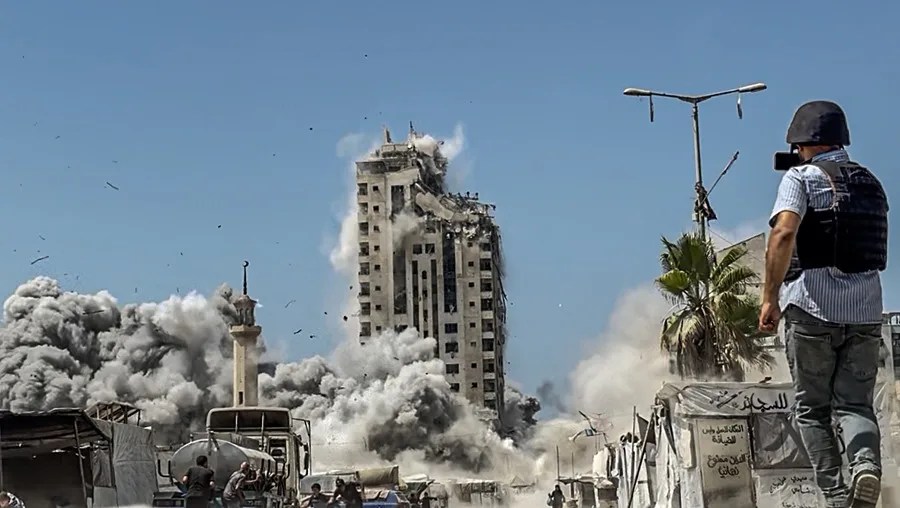 Un periodista filma un ataque aéreo israelí contra la Torre Mushtaha, al oeste de la ciudad de Gaza