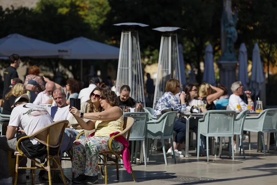 Varias personas disfrutan del buen tiempo en una terraza de Valencia en febrero.