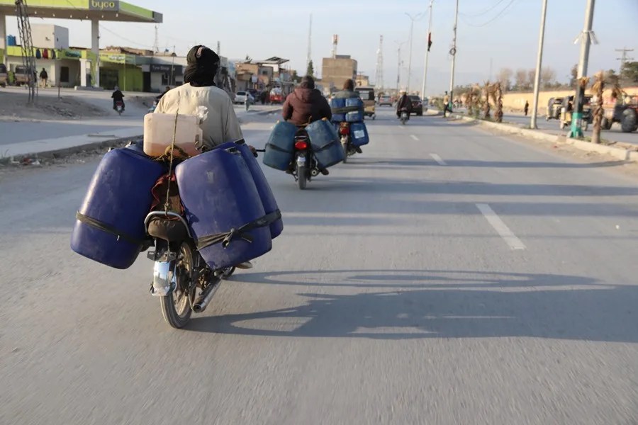 Vendedores transportan bidones llenos de gasolina en sus motocicletas en las afueras de Quetta