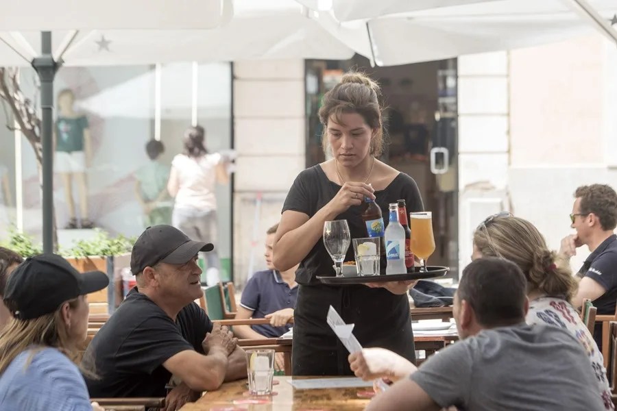 Una camarera trabaja en un bar de la ciudad de Mahón.