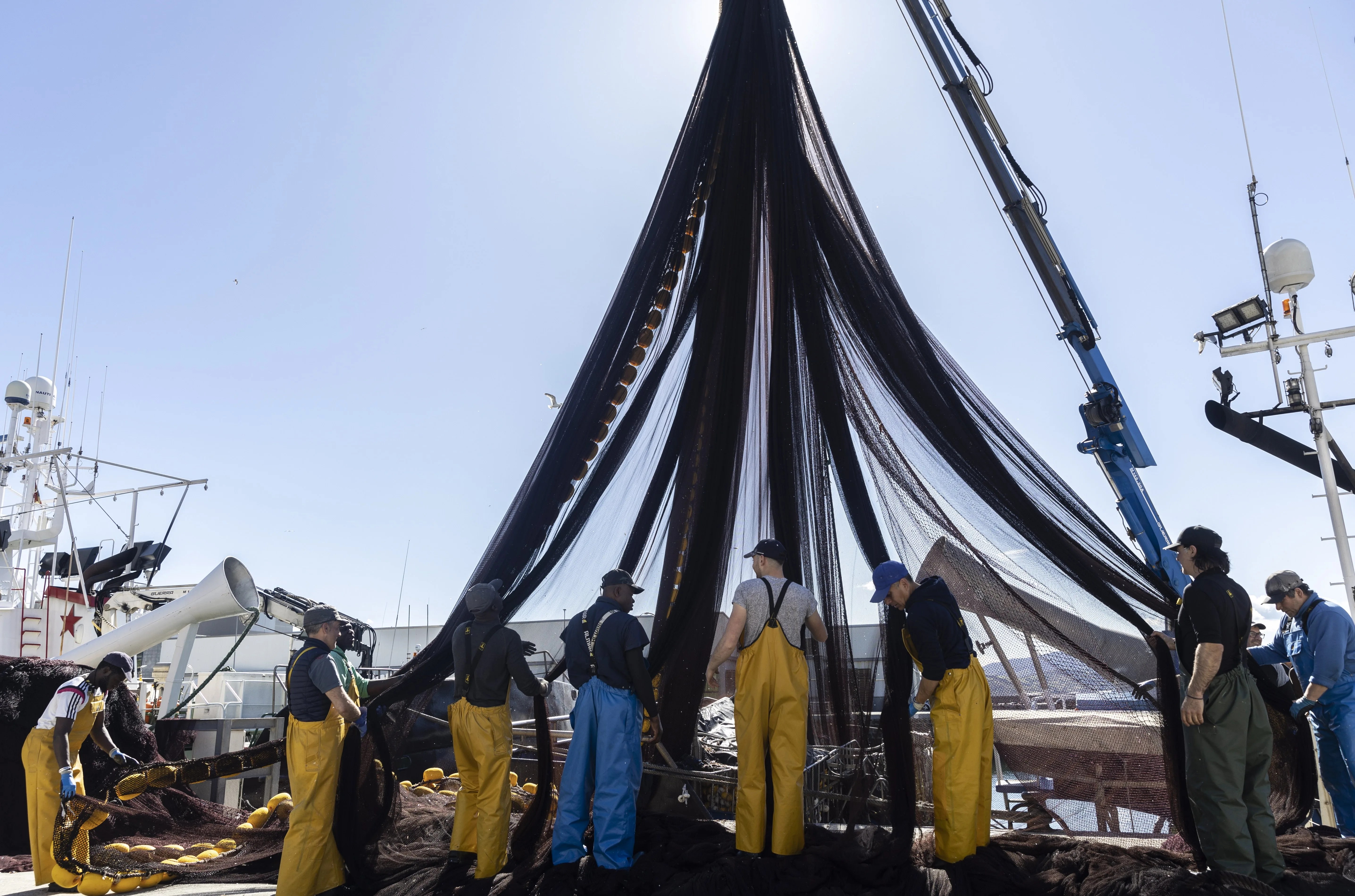 La tripulación de un barco pesquero limpia las redes en el puerto de Getaria (Gipüzkoa) tras descargar su cargamento de ancho, en una imagen de archivo.