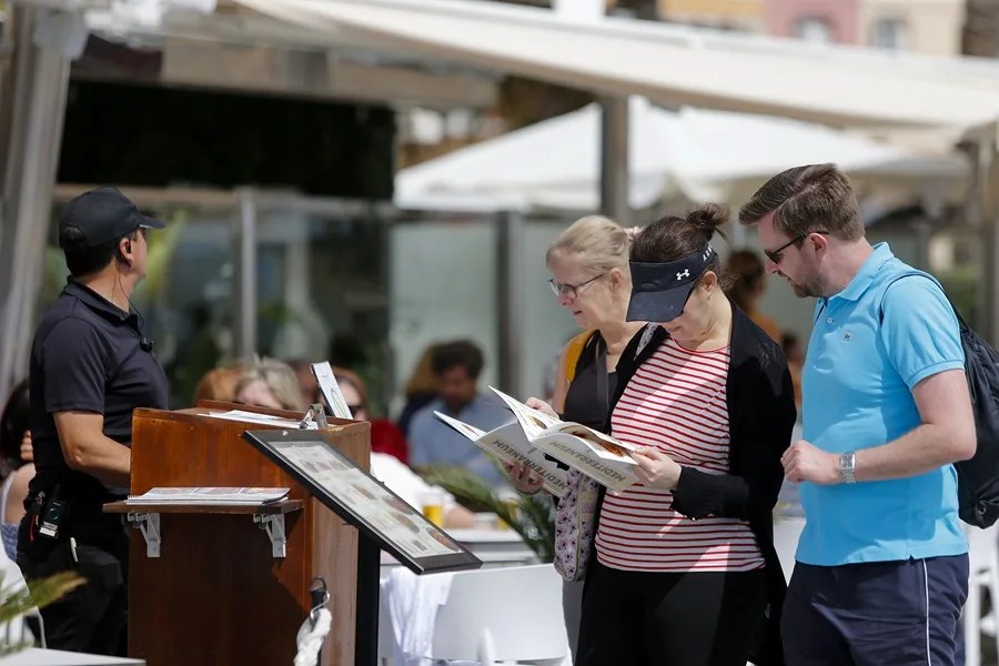 Unos turistas consultan la carta de un restaurante