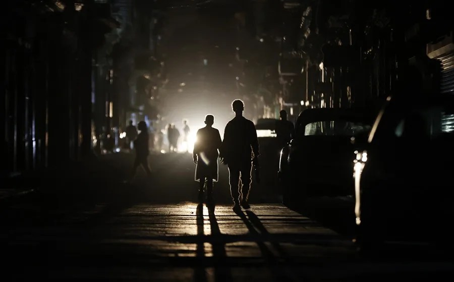 Fotografía de archivo de varias personas caminando por una calle sin electricidad en La Habana (Cuba). EFE/ Ernesto Mastrascusa